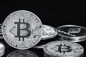 plata monedas con bitcoin símbolo en negro foto
