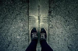 Woman's feet on the asphalt photo