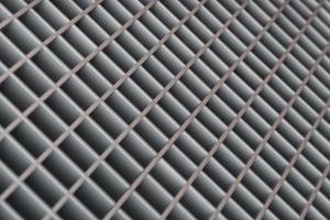 Abstract blurred diagonal lattice background from metal. Gray tint. photo