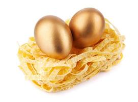 Pasta nest with golden eggs isolated on white background. photo