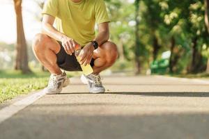 hombre trotar y caminando en el la carretera a Mañana con energía bebida agua, adulto masculino en deporte Zapatos corriendo en el parque afuera. ejercicio, bienestar, sano estilo de vida y bienestar conceptos foto