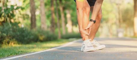 joven adulto masculino con su músculo dolor durante correr. corredor hombre teniendo pierna dolor debido a espinilla férulas Deportes lesiones y médico concepto foto