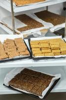 Assortment of cereal or protein bars that leave the assembly line at the factory. Healthy pre or post workout snacks with fruits, nuts and berries. photo