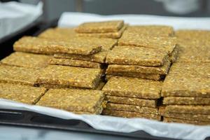 Assortment of cereal or protein bars that leave the assembly line at the factory. Healthy pre or post workout snacks with fruits, nuts and berries. photo