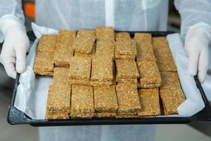 Assortment of cereal or protein bars that leave the assembly line at the factory. Healthy pre or post workout snacks with fruits, nuts and berries. photo