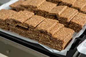 Assortment of cereal or protein bars that leave the assembly line at the factory. Healthy pre or post workout snacks with fruits, nuts and berries. photo