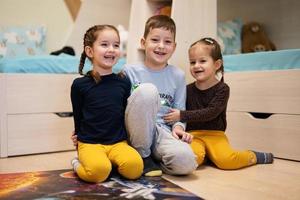 Children connecting jigsaw puzzle pieces in a kids room on floor at home.  Fun family activity leisure. photo