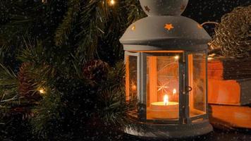 blanco linterna con un ardiente vela. libros, Navidad árbol rama y luces en antecedentes. nieve caer. noche oscuro fotografía. Navidad misterio humor. foto