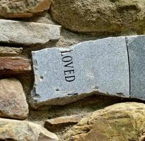 Broken gravestone with word loved photo