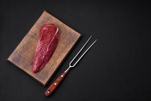 Beautiful fresh piece of raw beef on a wooden cutting board photo