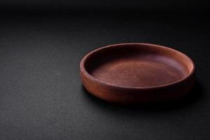 Empty brown colored ceramic plate on dark concrete background photo