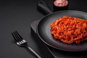 Dried squid chopped into slices and seasoned with sesame seeds and spices photo