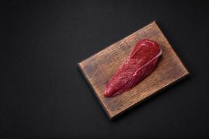 Beautiful fresh piece of raw beef on a wooden cutting board photo