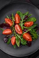 Salad of fresh cherry tomatoes, arugula, spinach and young beet leaves photo