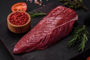 Beautiful fresh piece of raw beef on a wooden cutting board photo