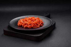 Dried squid chopped into slices and seasoned with sesame seeds and spices photo
