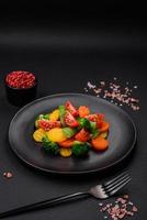 Salad of fresh and steamed vegetables cherry tomatoes, broccoli and carrots photo