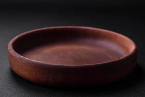 Empty brown colored ceramic plate on dark concrete background photo
