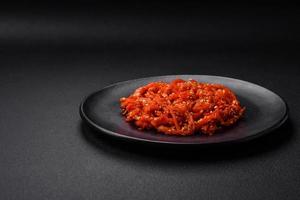Dried squid chopped into slices and seasoned with sesame seeds and spices photo