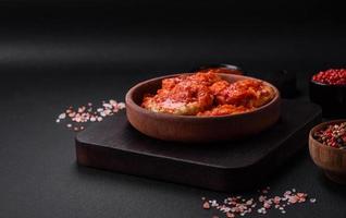 Delicious fresh cutlets or meatballs with spices, herbs and tomato sauce photo