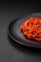 Dried squid chopped into slices and seasoned with sesame seeds and spices photo
