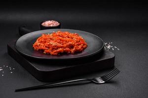 Dried squid chopped into slices and seasoned with sesame seeds and spices photo