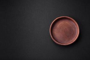 Empty brown colored ceramic plate on dark concrete background photo