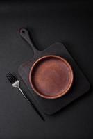 Empty brown colored ceramic plate on dark concrete background photo