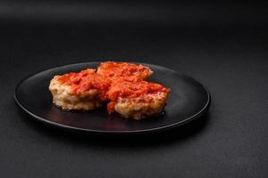 Delicious fresh cutlets or meatballs with spices, herbs and tomato sauce photo