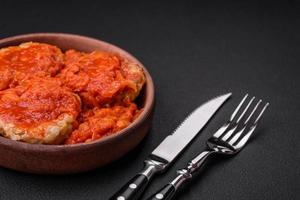 Delicious fresh cutlets or meatballs with spices, herbs and tomato sauce photo