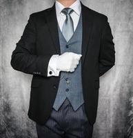 Portrait of Butler or Hotel Concierge in Dark Suit and White Gloves Eager to Be of Service. Concept of Elegant Hospitality and Professional Courtesy. photo