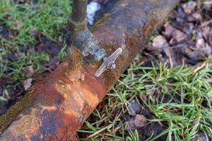 rusty water pipe with leaking tap photo