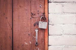 old brown wooden door locked with padlock photo