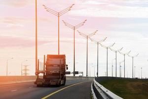 Car transporter truck drives on the highway in the evening photo