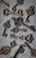 Retro keys collection on old wooden background photo