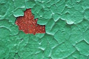 Green cracked enamel paint on rusty wall photo