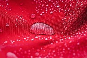 Large water drop on red waterproof fabric photo