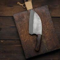 Knife and wooden board, top view photo