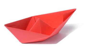 Red paper boat on a white isolated background photo