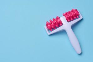 A plastic body massager on a blue background, top view. Body care. photo