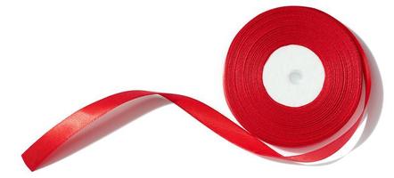 A spool with a red silk ribbon on a white isolated background, an object for decoration photo