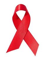 un seda rojo cinta en el formar de un arco es aislado en un blanco fondo, un símbolo de el lucha en contra SIDA y un firmar de solidaridad y apoyo. foto