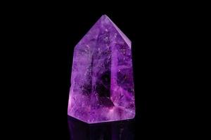 Macro mineral stone Amethyst crystal on a black background photo