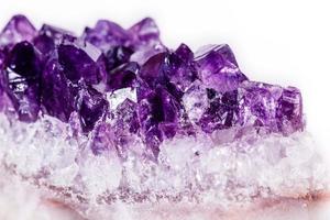 Macro mineral stone purple amethyst in crystals on a white background photo