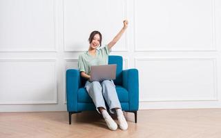 image of young Asian girl sitting on sofa at home photo