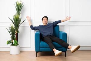 portrait of asian man sitting on sofa at home photo