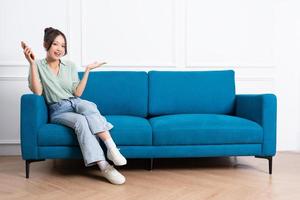 imagen de joven asiático niña sentado en sofá a hogar foto
