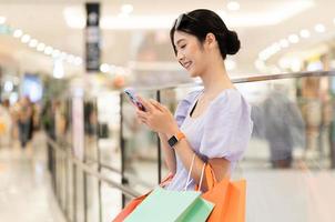 contento asiático mujer compras a centro comercial foto