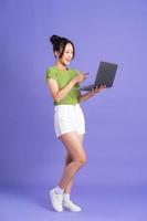full body image of beautiful asian girl posing on pink background photo
