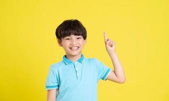 portrait of an asian boy posing on a yellow background photo